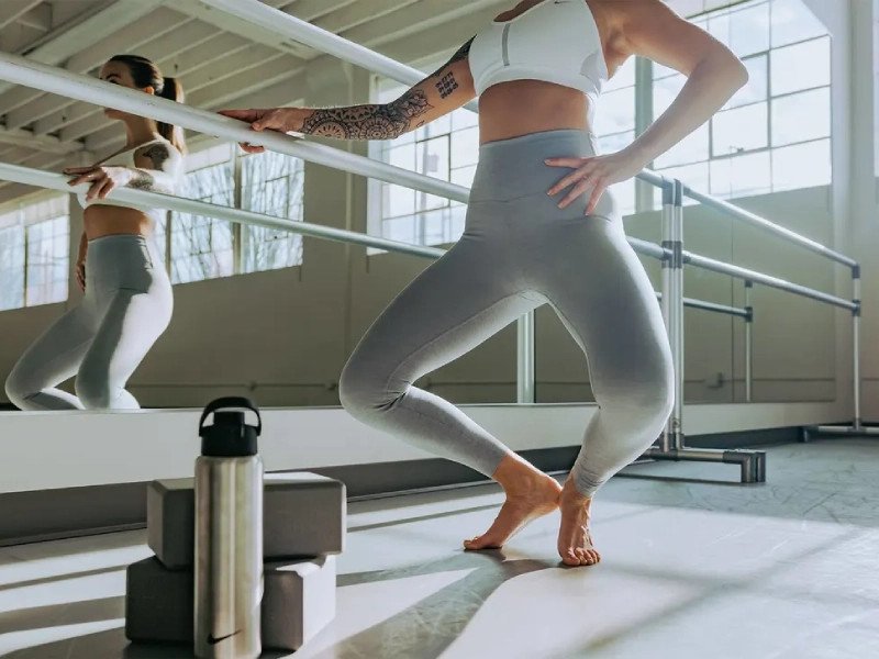 Hình ảnh minh họa tư thế đúng khi tập Barre, với lưng thẳng, vai mở, cơ bụng siết chặt, thể hiện sự tập trung vào việc cải thiện alignment và tăng cường sức mạnh cơ trung tâm.