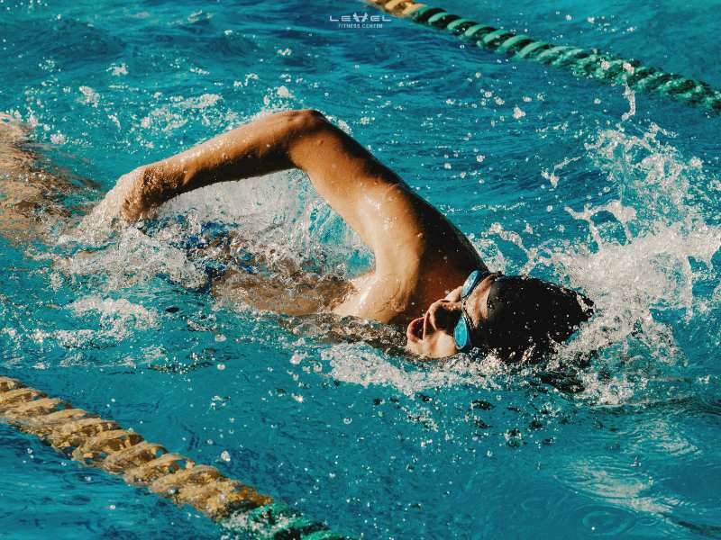 Bơi lội giảm cân: Hình ảnh một vận động viên bơi lội đang thực hiện kiểu bơi tự do, thể hiện sự mạnh mẽ và hiệu quả của bơi lội trong việc giảm cân