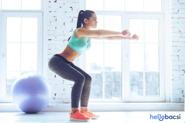 Hình ảnh phụ nữ thực hiện đúng kỹ thuật bài tập sumo squat.