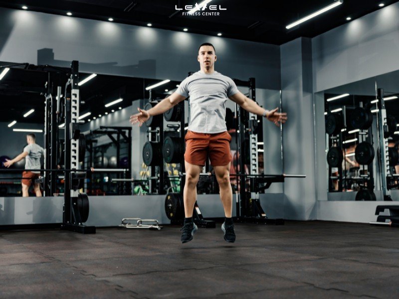 Hình ảnh minh họa động tác Jumping Jack, người tập đứng thẳng, nhảy lên dang tay chân.