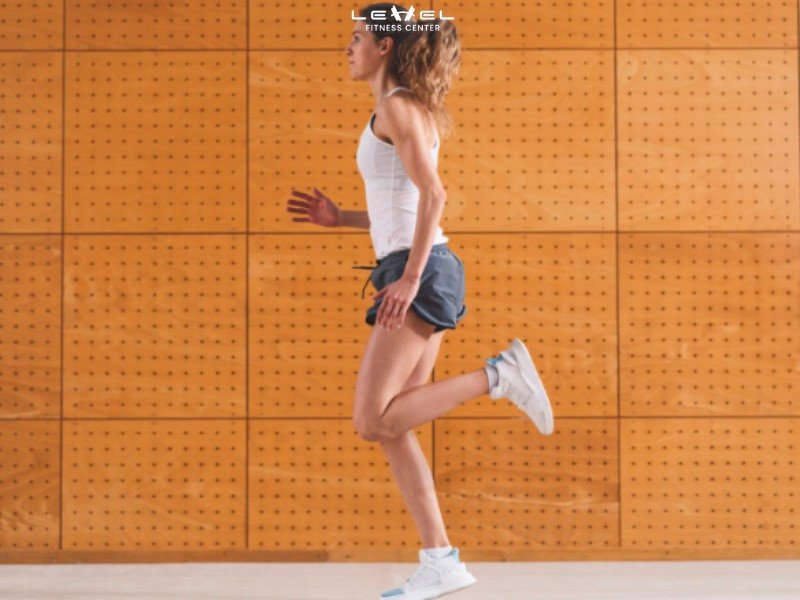 Hình ảnh minh họa động tác High Knees, người tập chạy tại chỗ nâng cao đùi.