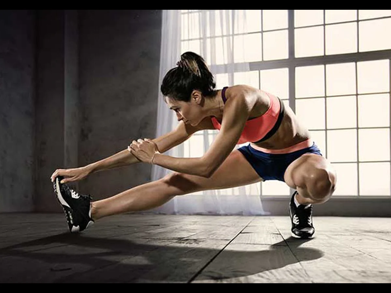 Người tập gym thực hiện các động tác khởi động hoặc kéo giãn.