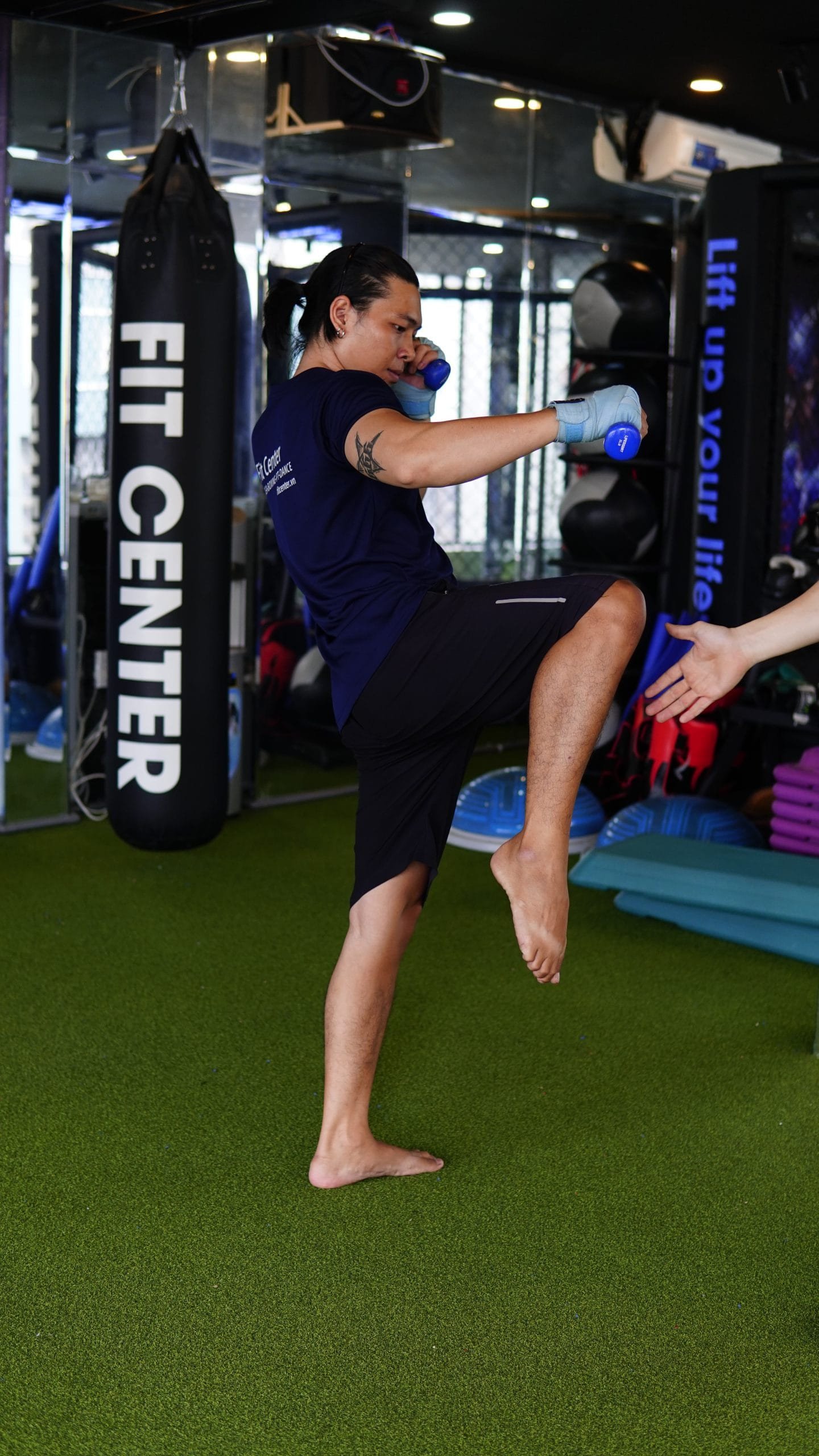 Mô tả người thực hiện đòn đá vòng thấp (low kick) trong tập luyện Muay Thai, tập trung vào kỹ thuật xoay hông và ống chân tiếp xúc mục tiêu.