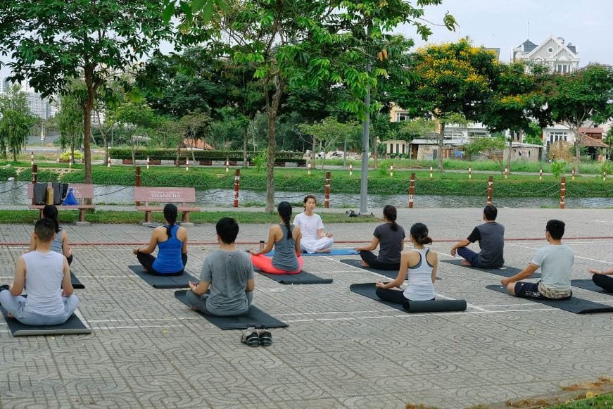 Người phụ nữ mỉm cười thư thái nhìn về phía chân trời, thể hiện sự giải tỏa căng thẳng và tâm hồn an lạc từ lợi ích của Karma Yoga