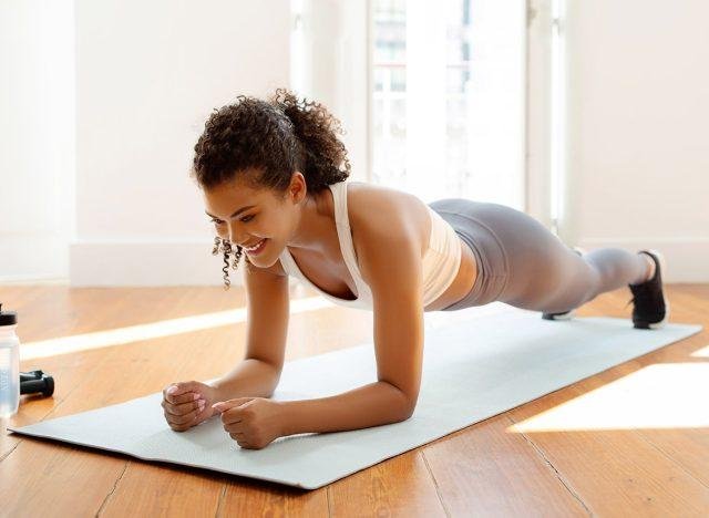 Các Bài Tập Gym Cho Nữ Mới Bắt Đầu: Hướng Dẫn Chi Tiết Phụ nữ giữ tư thế plank trên cẳng tay, cơ thể thẳng tắp, siết chặt cơ bụng
