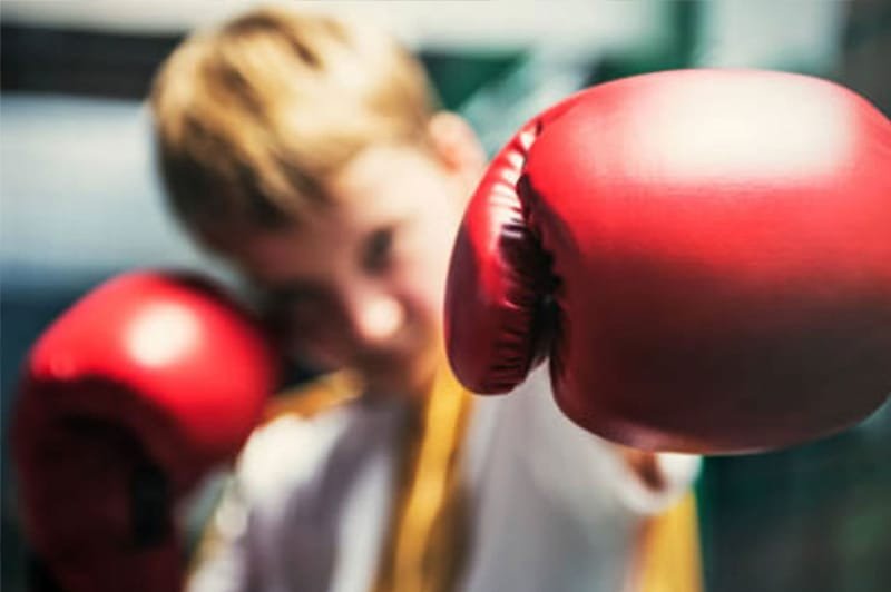 Trẻ em tập đấm bao cát, minh họa lợi ích rèn luyện thể chất